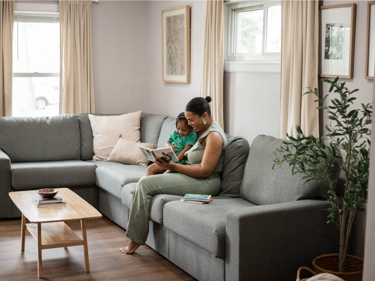 Parent and child relaxing on a Home Reserve sectional